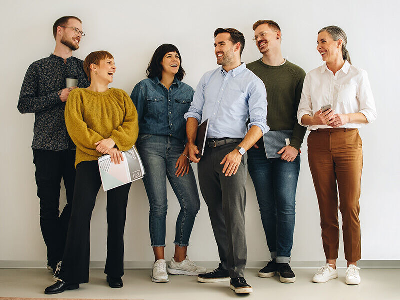 Gruppe von 6 Menschen, die sich freuen und lachen