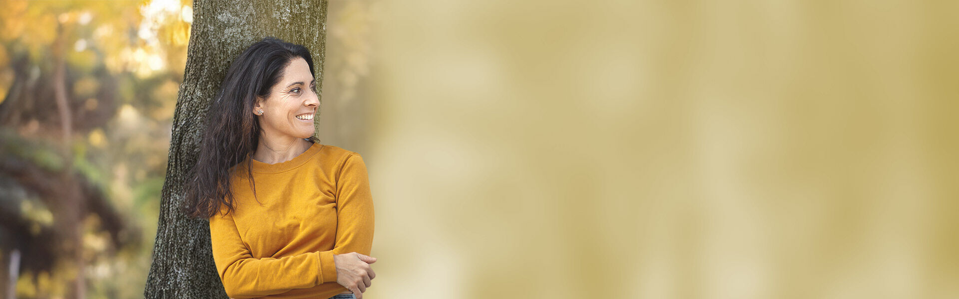 eine Frau, die sich an einen Baum lehnt