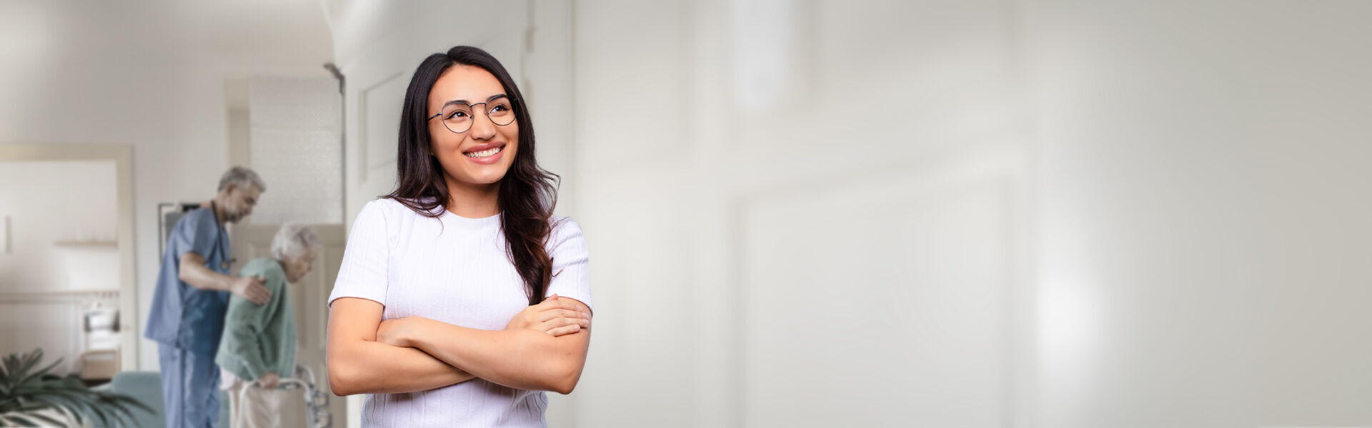 eine lächelnde Frau steht im Flur einer Seniorenresidenz